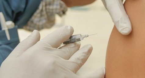 Nurse holding a vaccine near a patient's arm